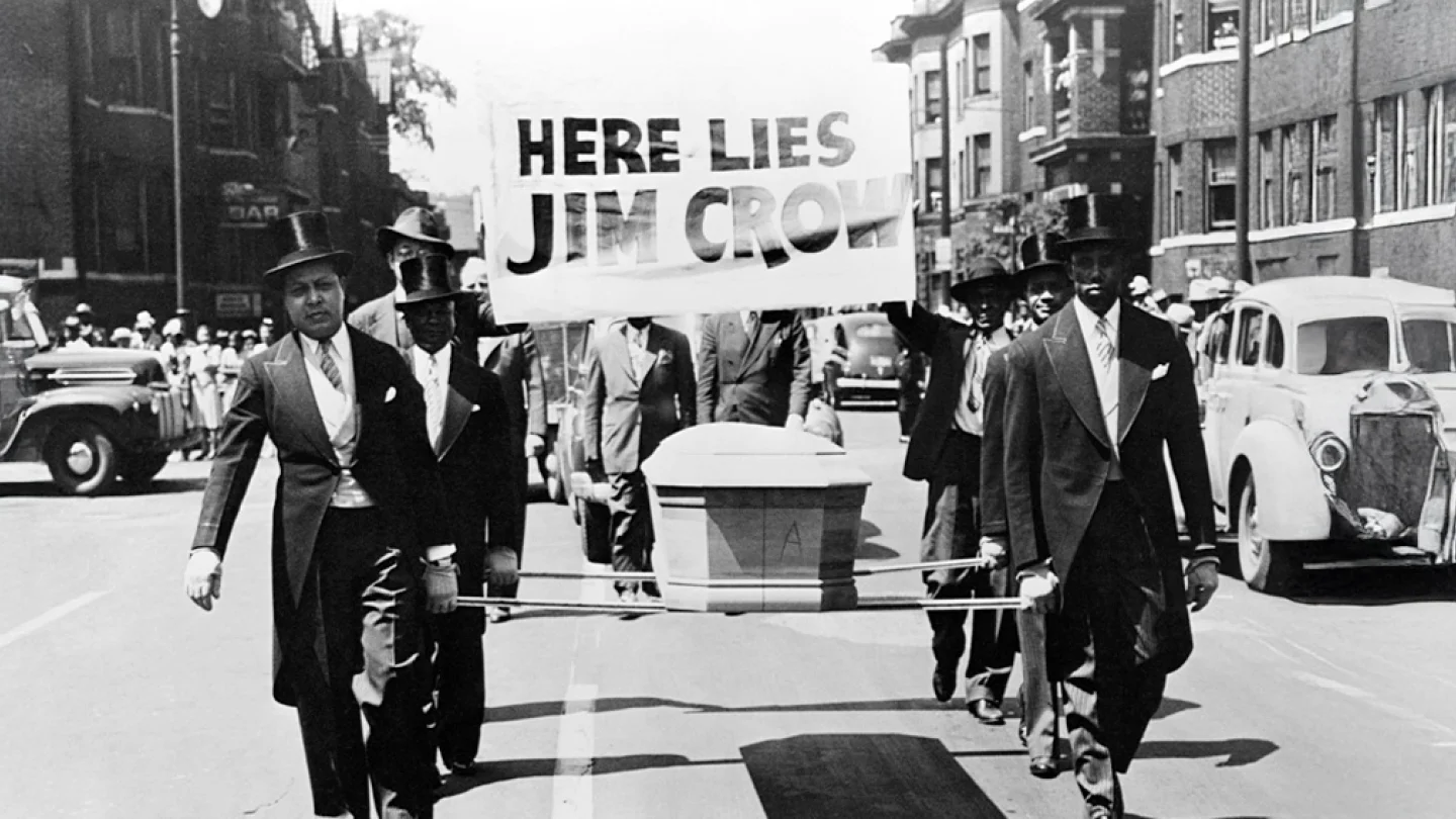 Üzerinde "Jim Crow burada yatıyor" yazan bir pankartla bir tabut taşıyan Siyahlar, ırk ayrımcılığının resmen sona ermesini kutluyor.