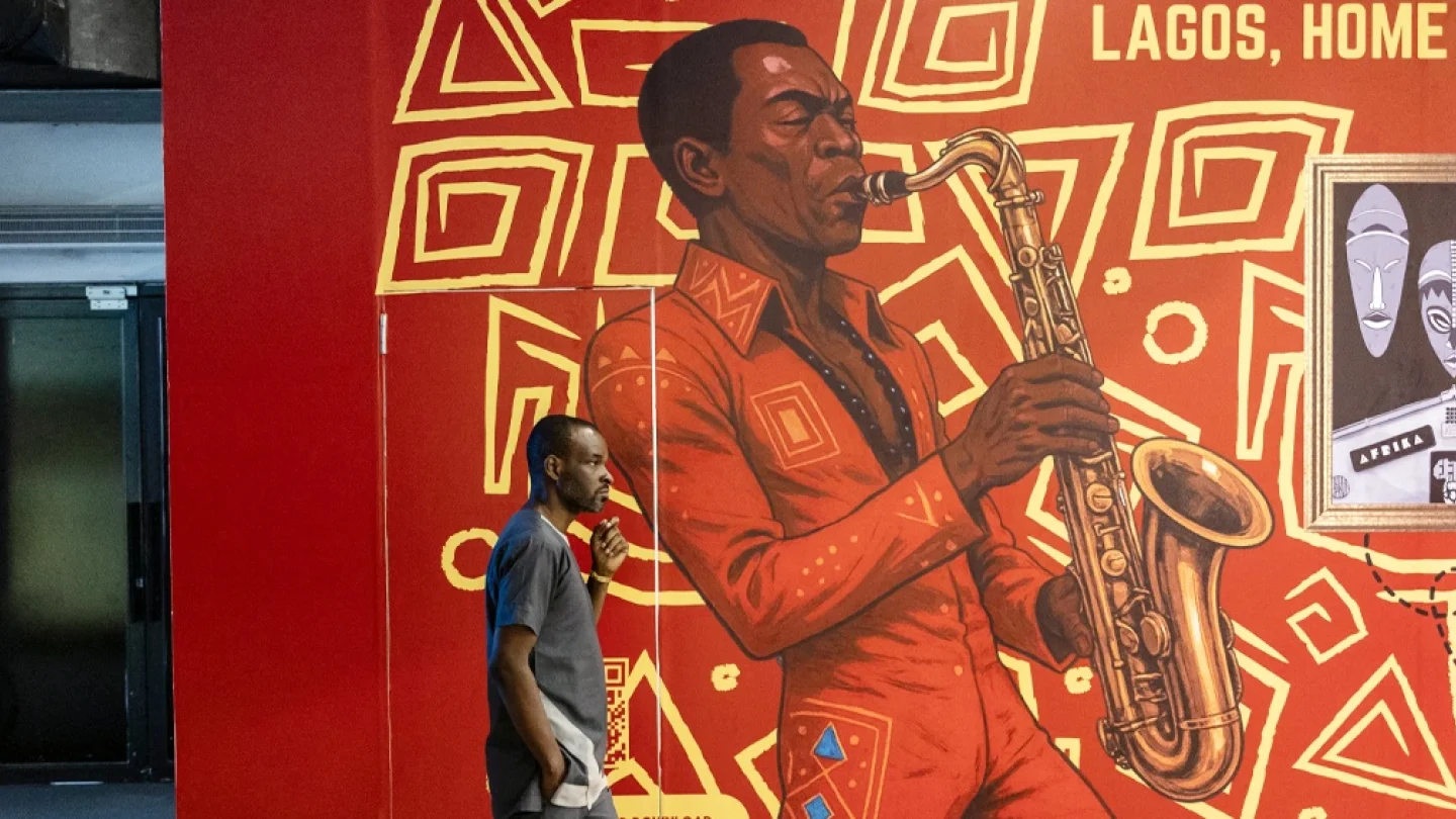 Fela Anikulapo Kuti sergisinin açılış gecesi sırasında Fela Kuti'yi tasvir eden resmin önünden geçiyor./foto:AFP