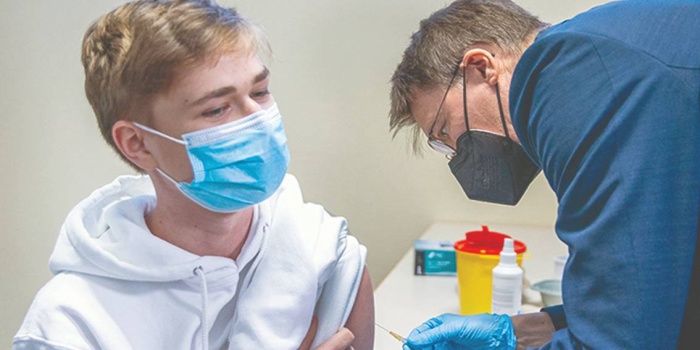 Alman Sağlık Bakanı Karl Lauterbach (sağda), 17 Ocak’ta Schwerin kentindeki aşı merkezinde bir gence bizzat aşı yaptı. Foto: AFP