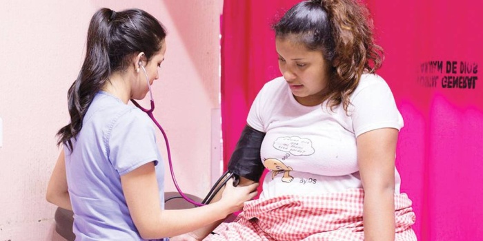 Guatemala'da bir hemşire, doğum yapan 16 yaşındaki bir çocuğu muayene ediyor. 