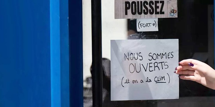 Fransa'da bir mağazanın kapısında “Açığız, klimamız var